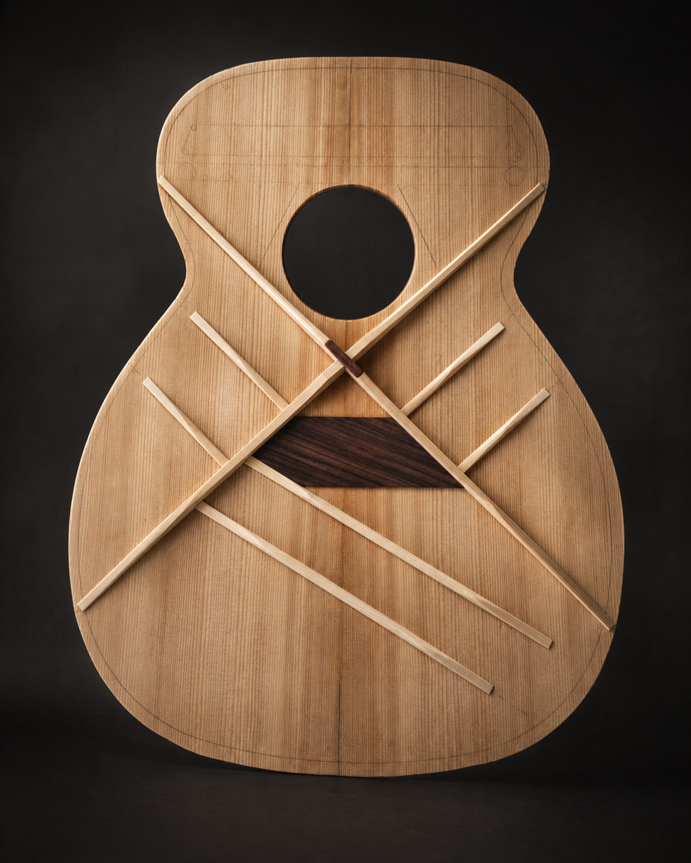 Manifestation III in incubation at Stone Guitars — an Adirondack spruce top with hand-shaped X-bracing laid out before gluing, on the workbench of luthier Devon Stone in Birmingham, Alabama.